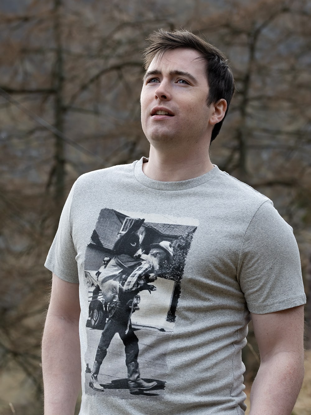 man wearing a grey recycled cotton t-shirt with a print of a man carrying a donkey